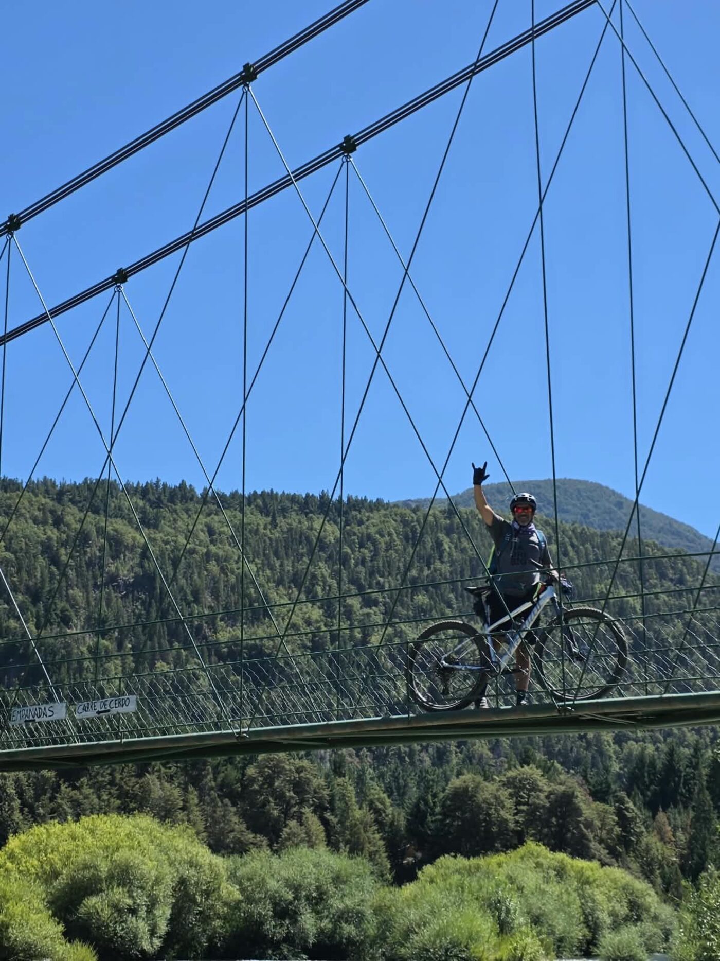 Ciclista cruzando un puente colgante