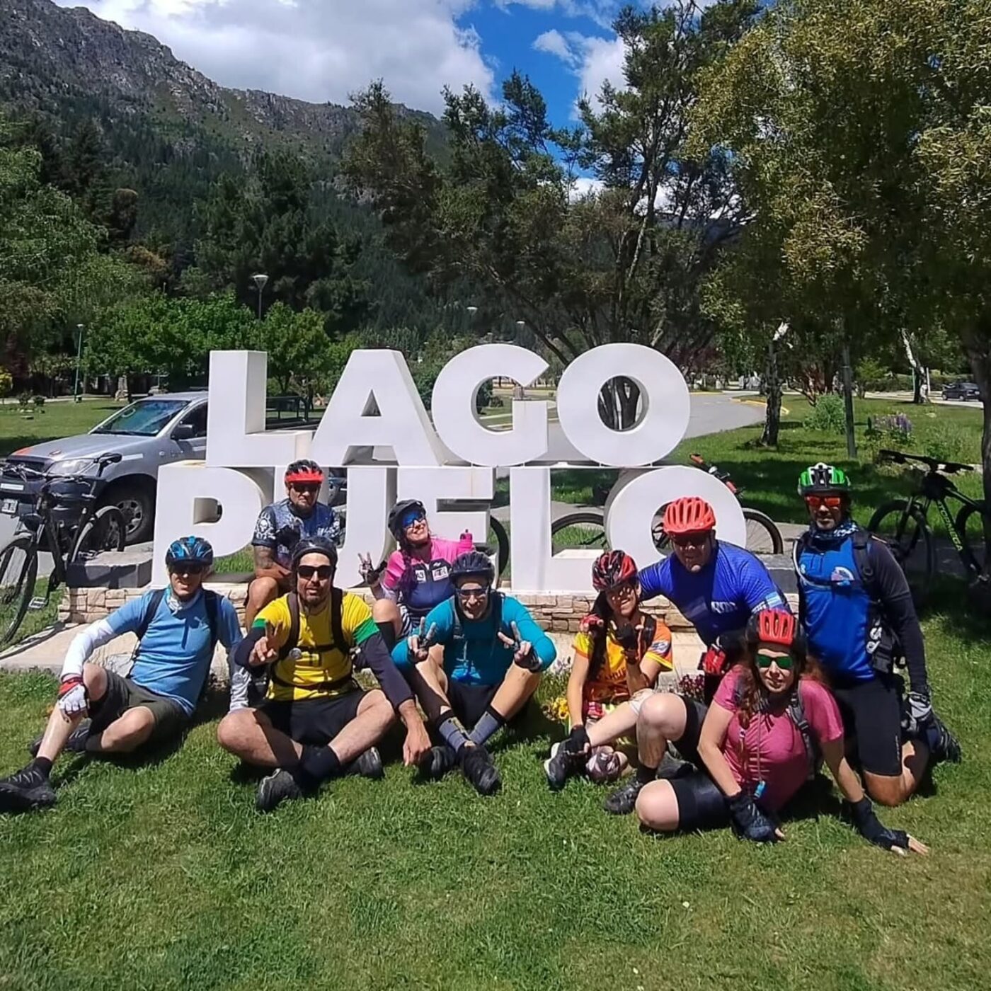 Grupo con bicicletas en cartel de Lago Puelo