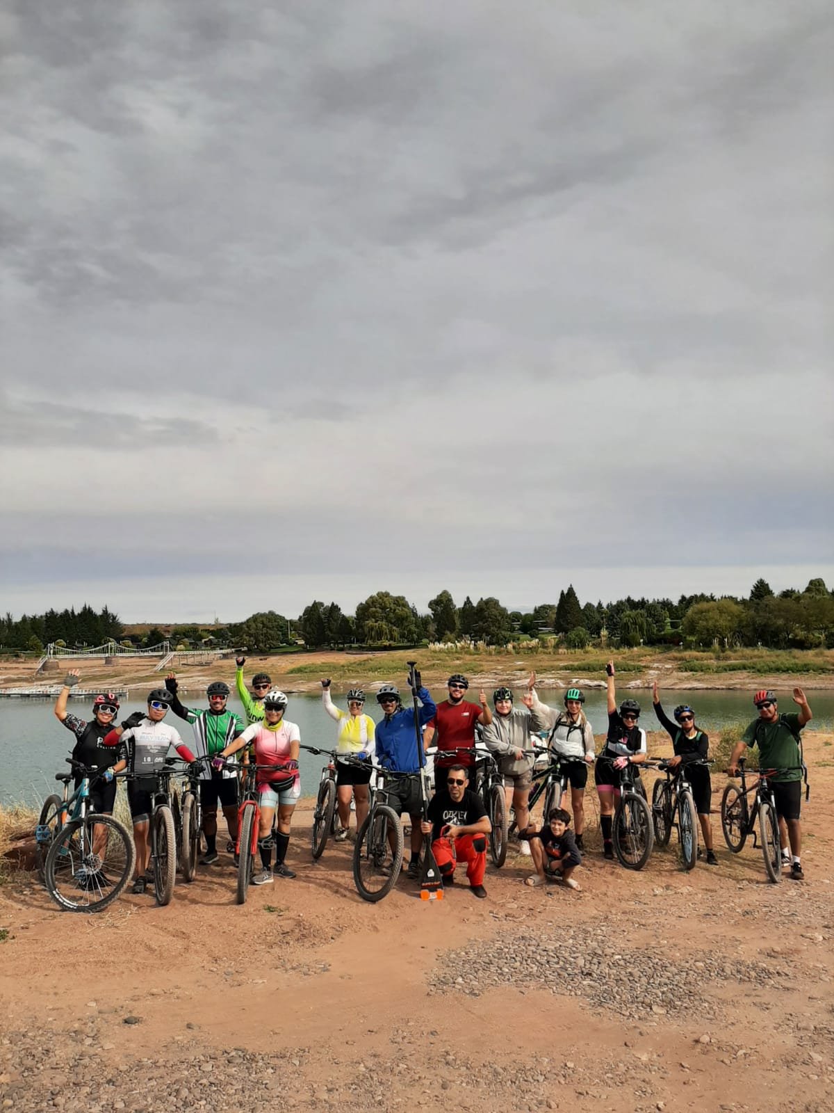Grupo grande de ciclistas festejando junto al lago